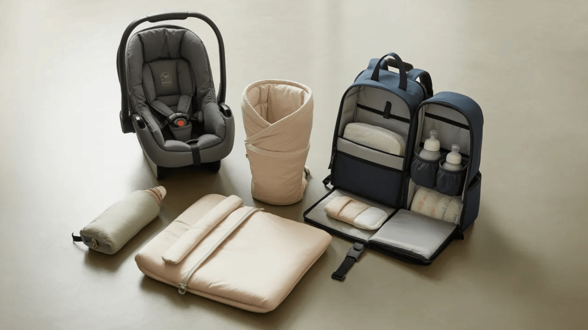 a clean, organized flat lay on a light grey surface featuring baby travel essentials
