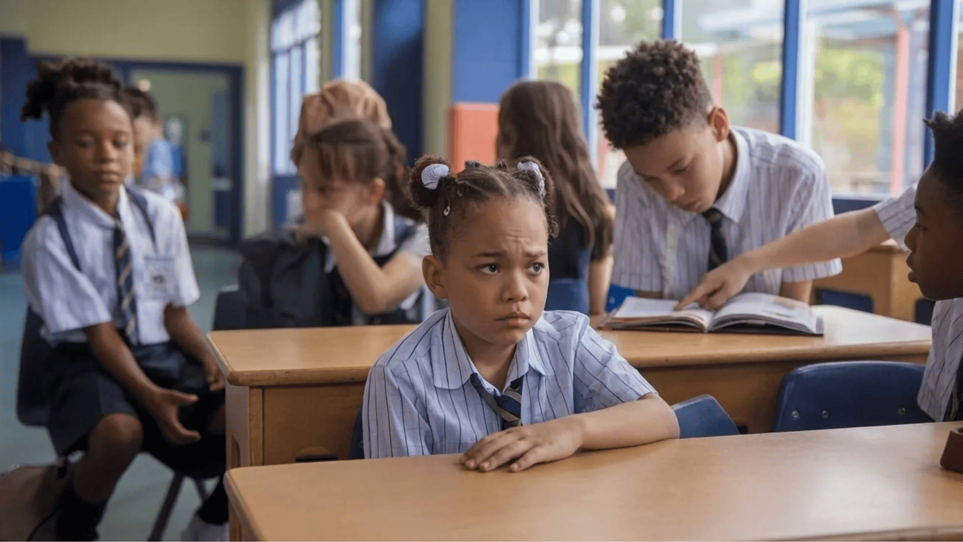 a scared girl sitting on a bench around other students
