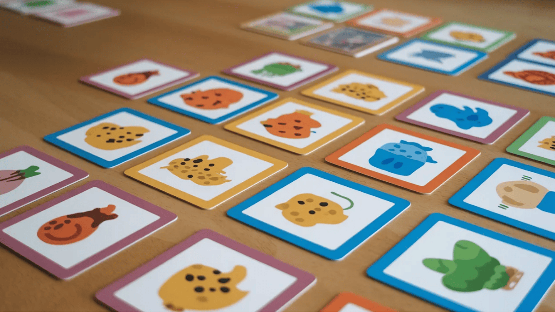 colorful memory matching cards with animal illustrations arranged face down on a table for a kids game activity
