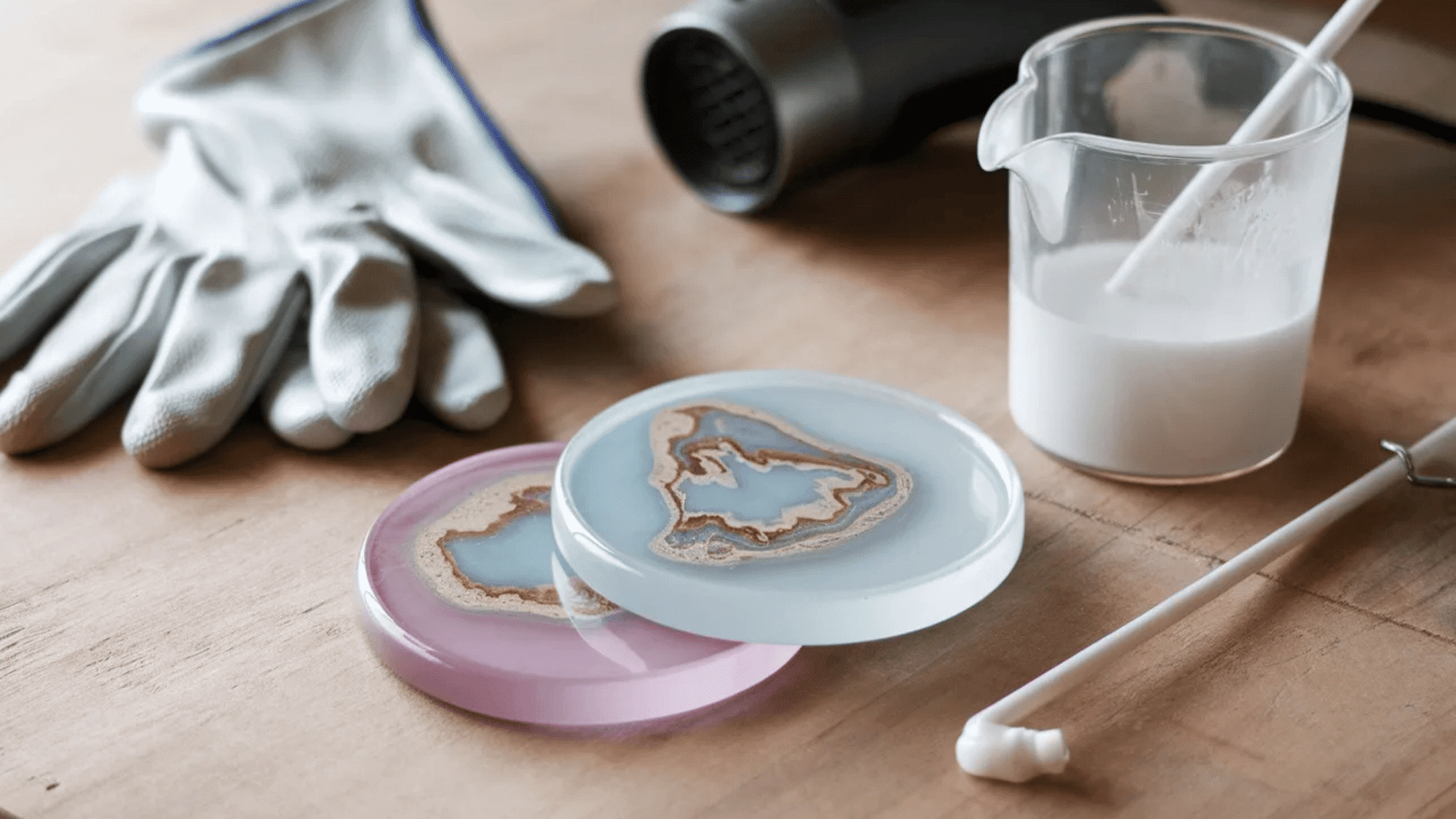 diy resin coasters in pink and blue colors, with materials on the side