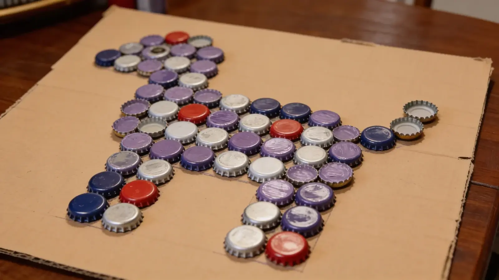 Bottle caps arranged on cardboard forming a bird shape