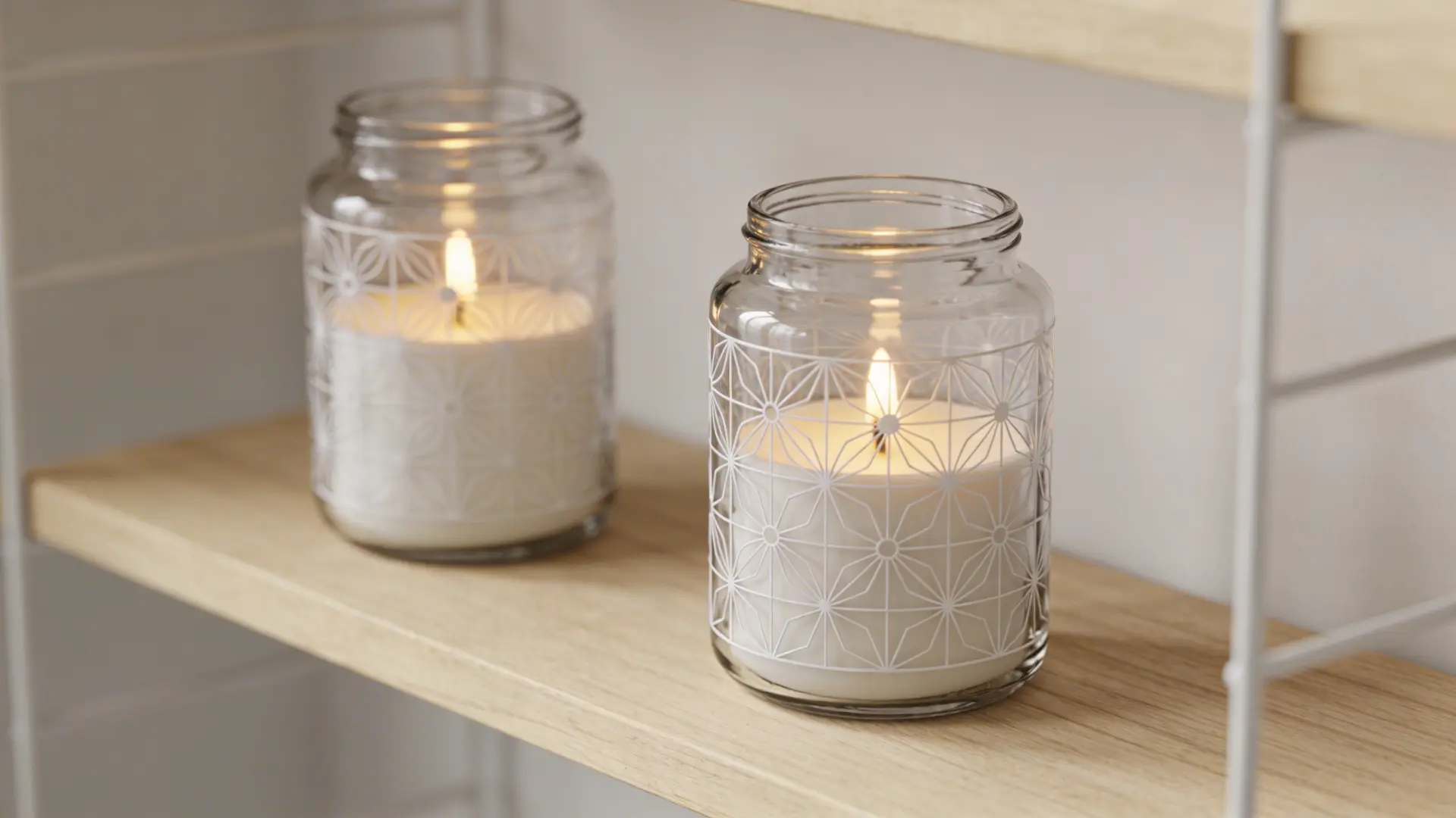 Decorated glass jars holding candles placed indoors