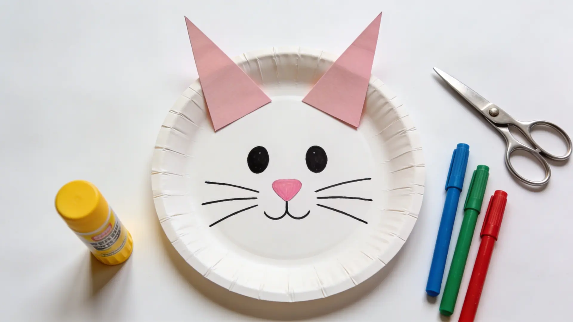 Paper plate bunny face with drawn features and attached paper ears