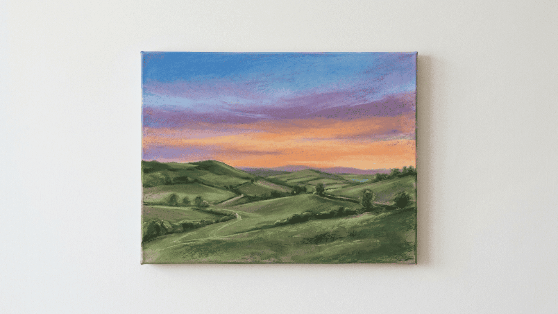 chalk pastel landscape on a front facing canvas with soft blended sunset sky in blue purple and orange above green hills