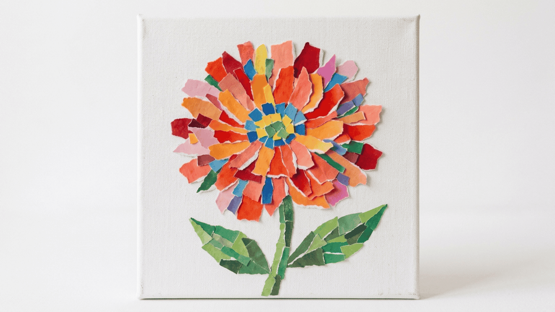colorful paper mosaic collage with small cut pieces arranged into a flower pattern on a white canvas