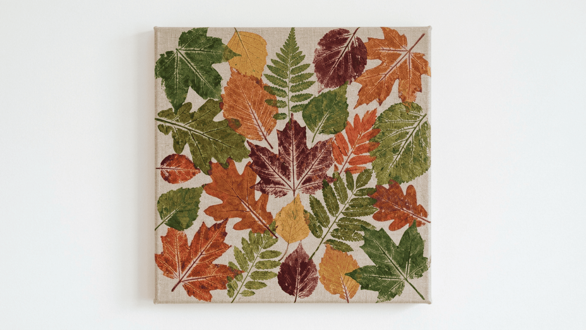 nature leaf print composition on a front facing canvas with overlapping painted leaf prints in green orange and red tones