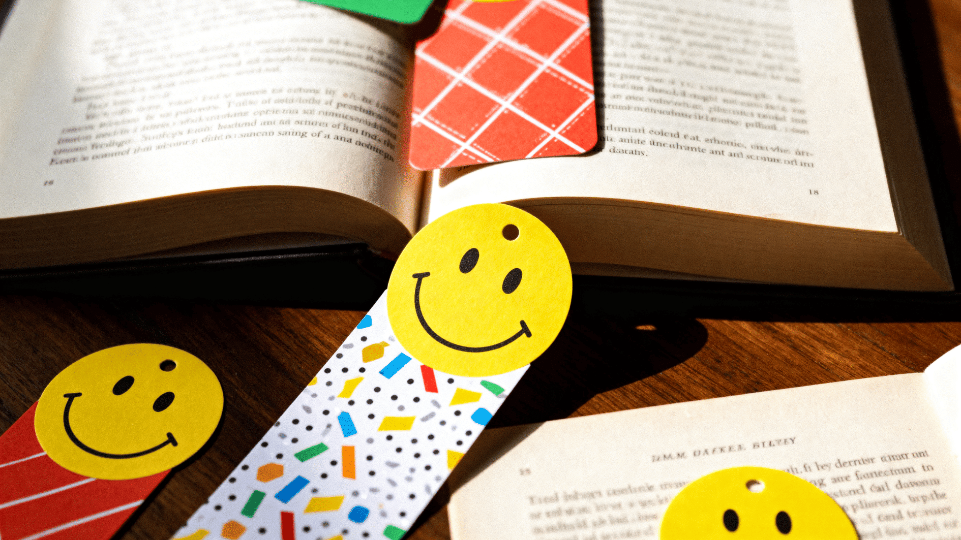 smiley face bookmarks placed in open book, adding a cheerful and creative touch to reading materials