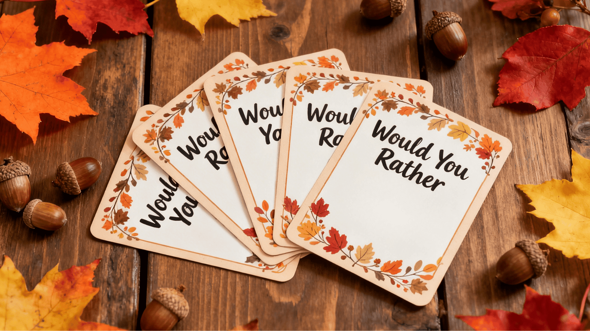 “would you rather” cards with fall-themed design placed on wooden table with leaves and acorns for a fun game