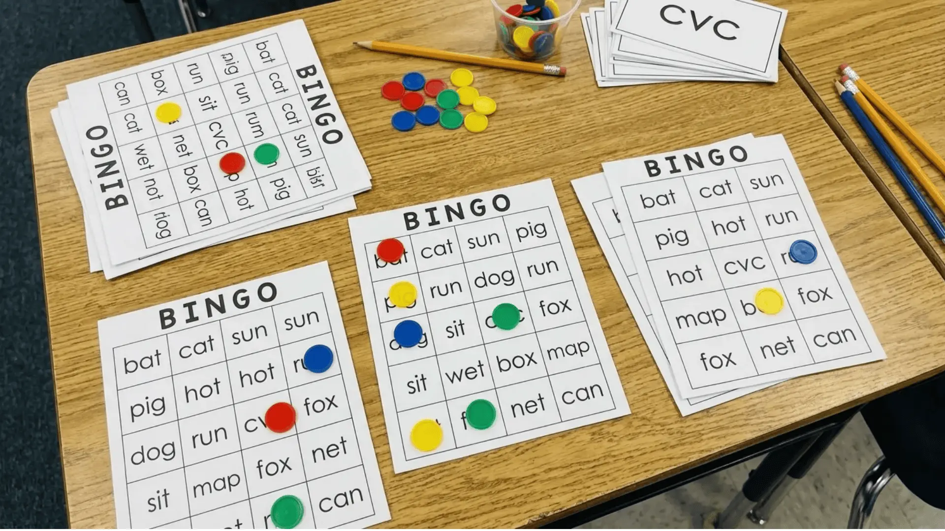 Bingo cards with CVC words and markers placed on squares for a classroom phonics game.
