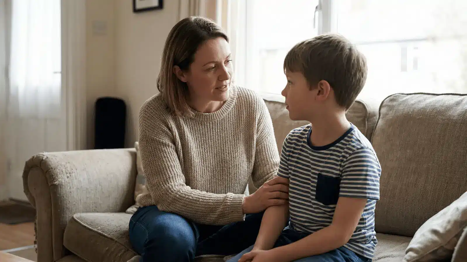 Adult sitting with a child and speaking calmly during a quiet moment