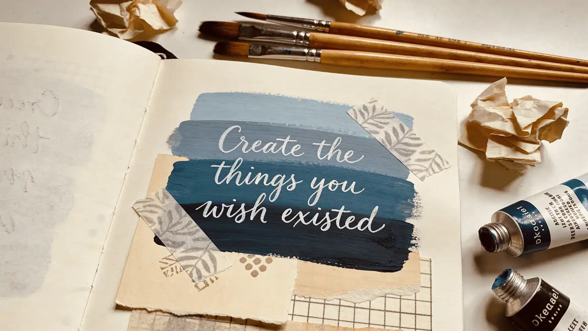 Art journal page with handwritten quote in center surrounded by layered paint and collage elements