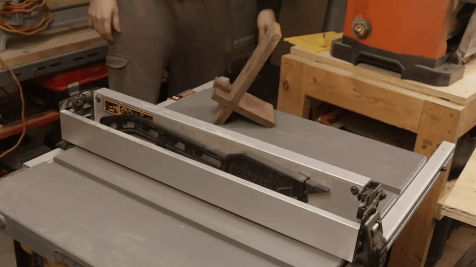 Assembled wooden phone stand placed on a table saw surface, showing final shape and structure