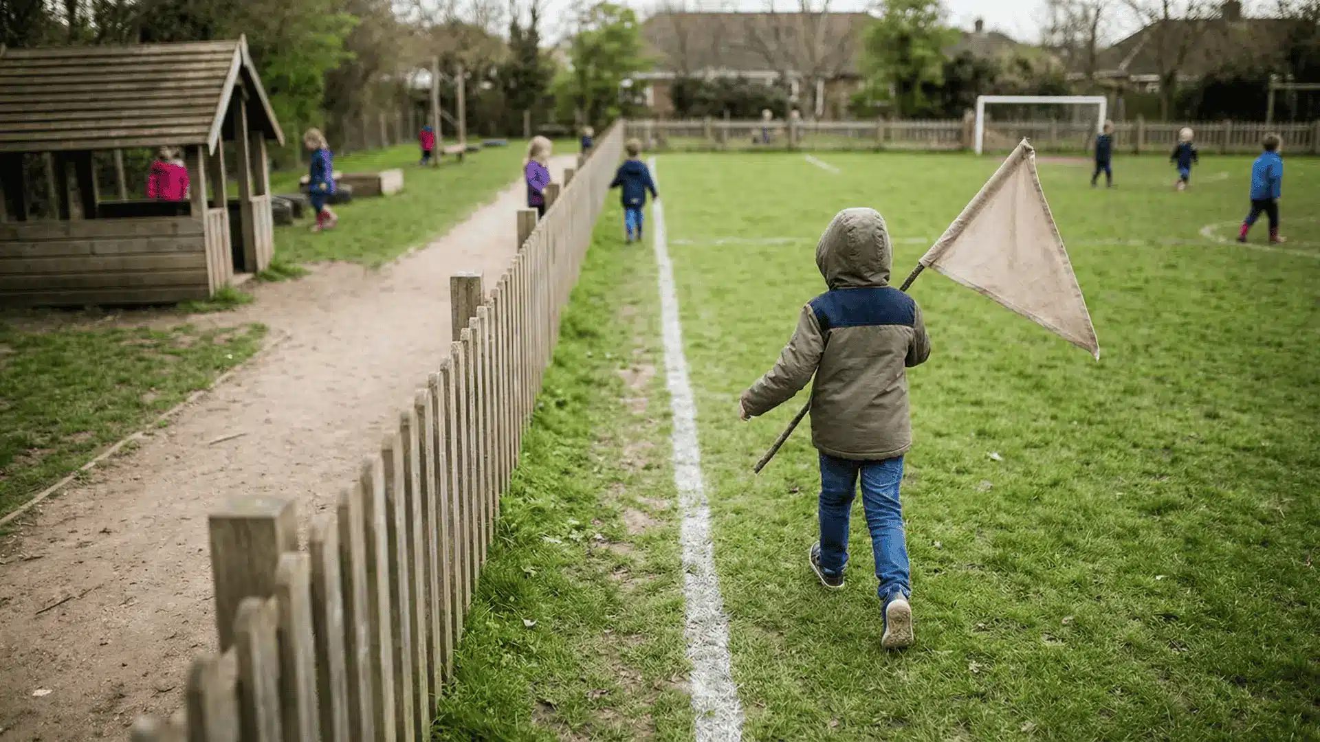 Child running with a flag across a divided play area