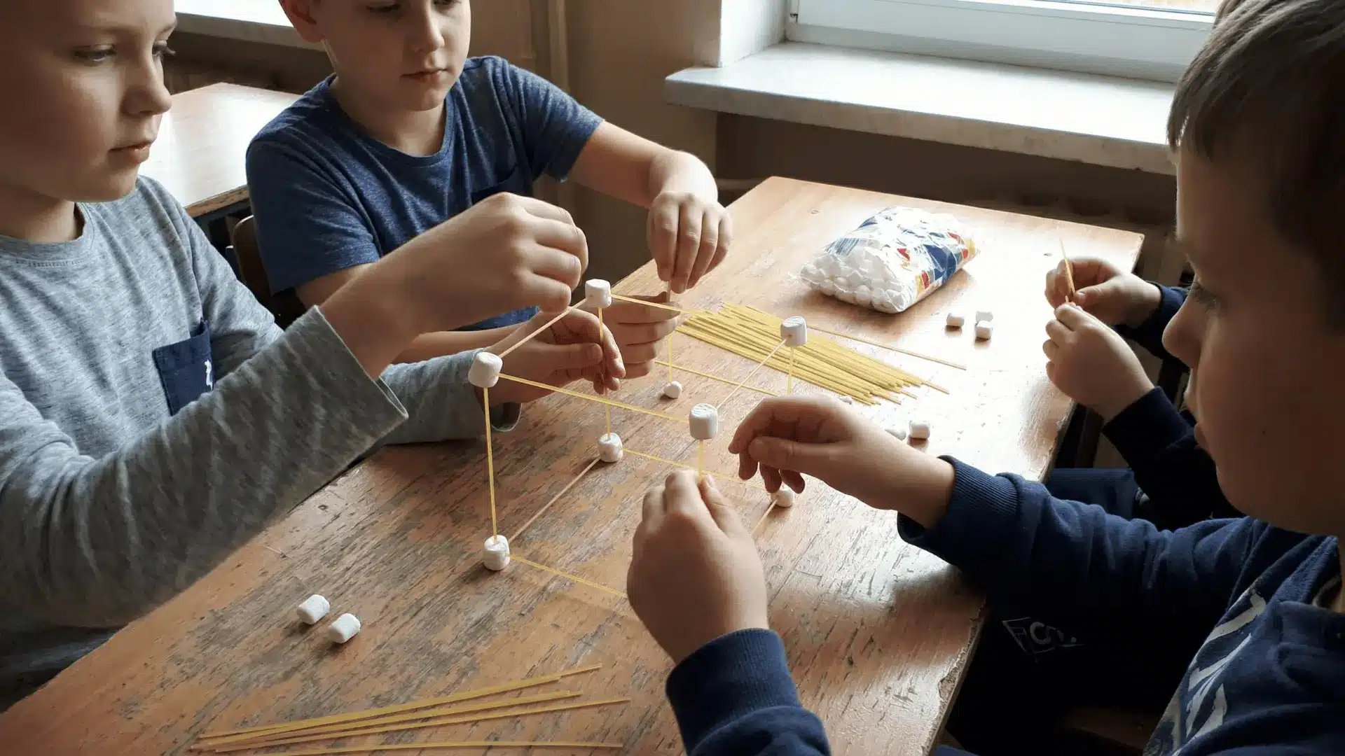 Children building a tower using spaghetti and marshmallows