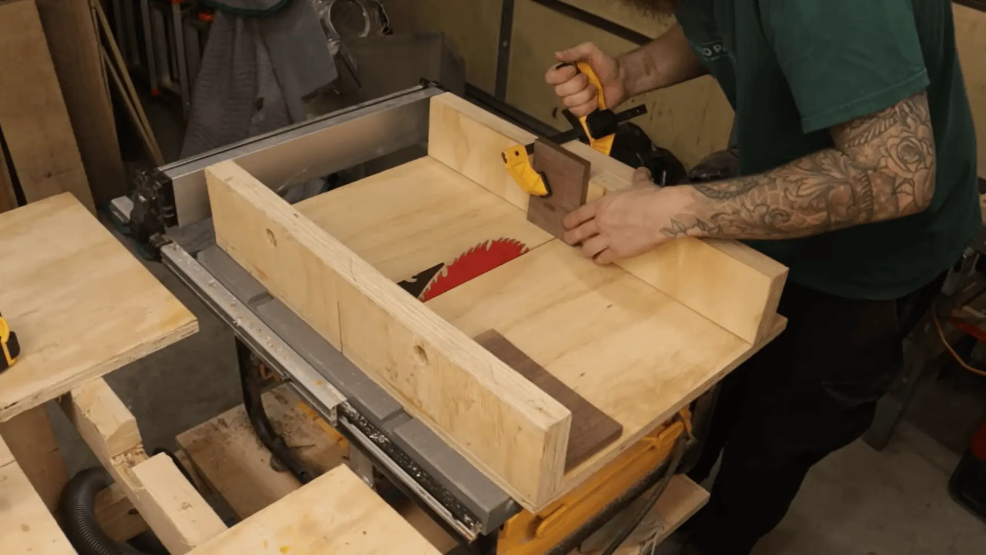 Cutting a wooden board to size on a table saw using a crosscut sled and clamp for support