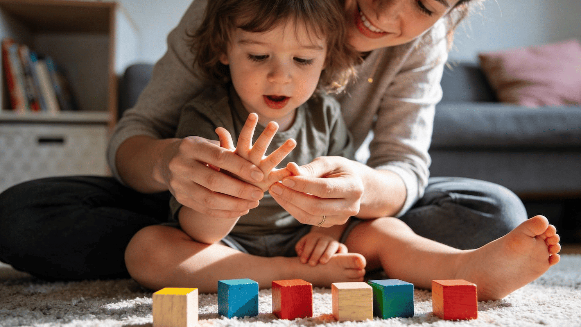 mother teaching toddler counting with fingers and colorful blocks during early childhood learning activity