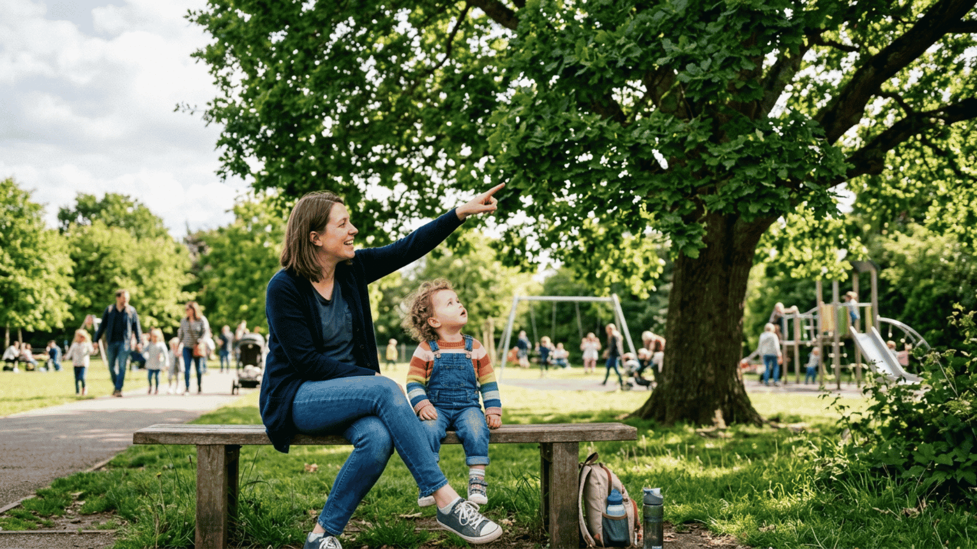 parent pointing at a tree while toddler watches during outdoor speech learning activities in a park