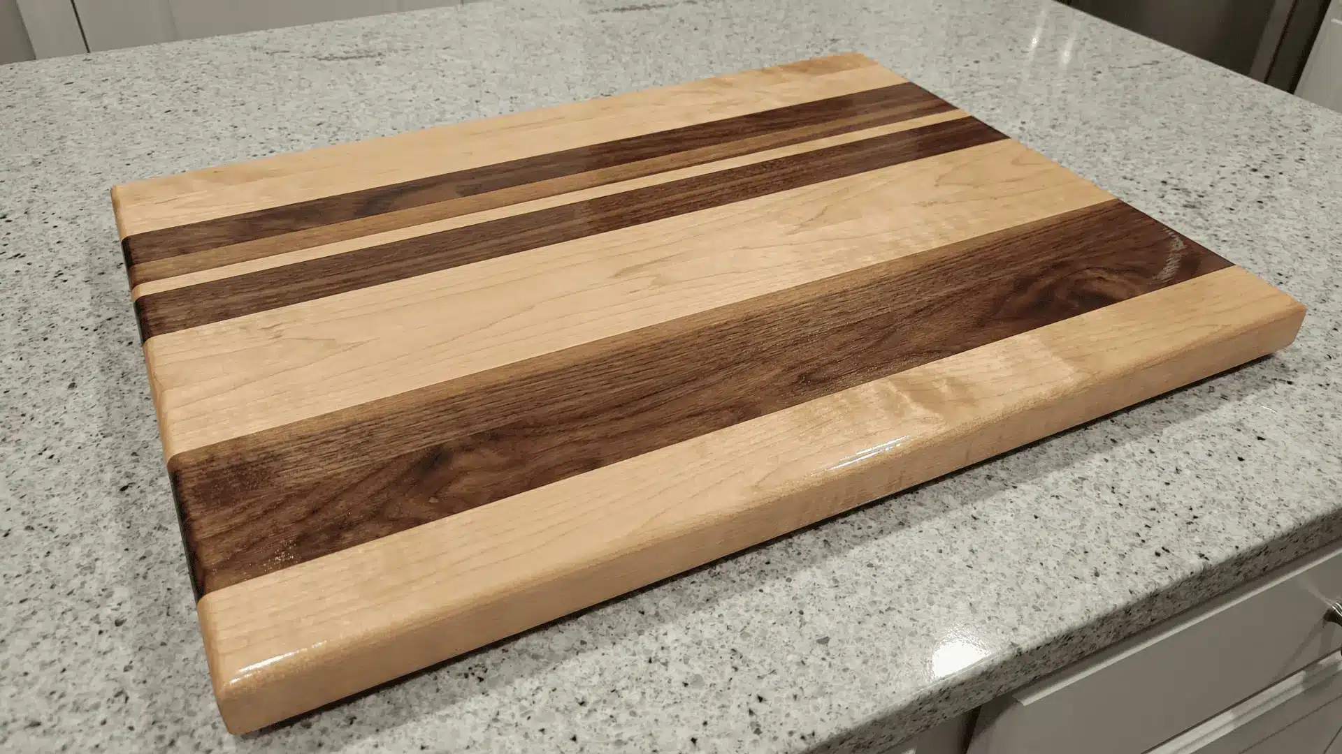 Wooden cutting board made of joined wood strips with a smooth sealed surface on a kitchen countertop