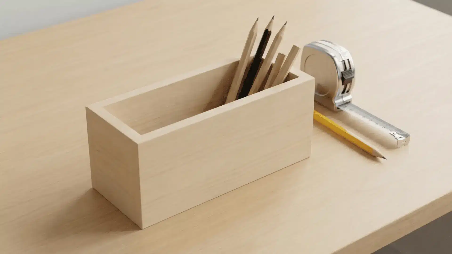 Wooden pencil holder with straight sides holding pencils on a desk with measuring tape nearby