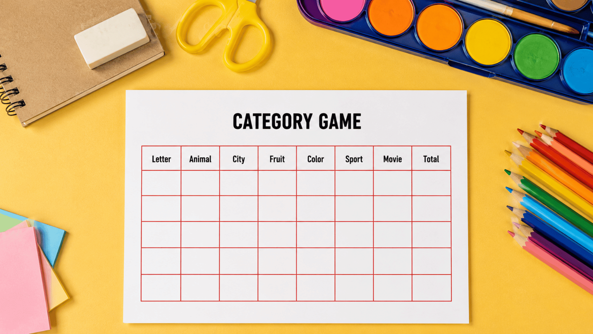 categories pen and paper desk game setup with colorful pencils and craft table setup on both sides yellow desk and white paper