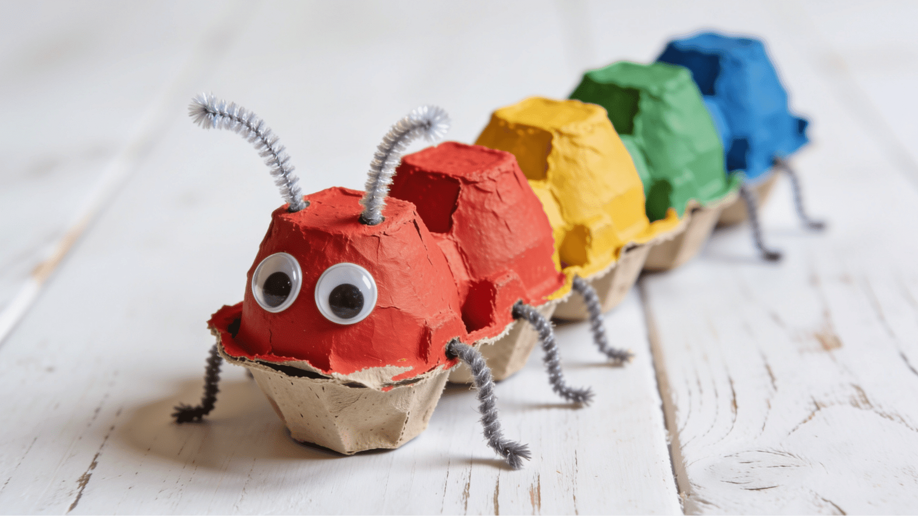egg carton caterpillar with painted segments in red yellow green and blue with googly eyes and pipe cleaner legs