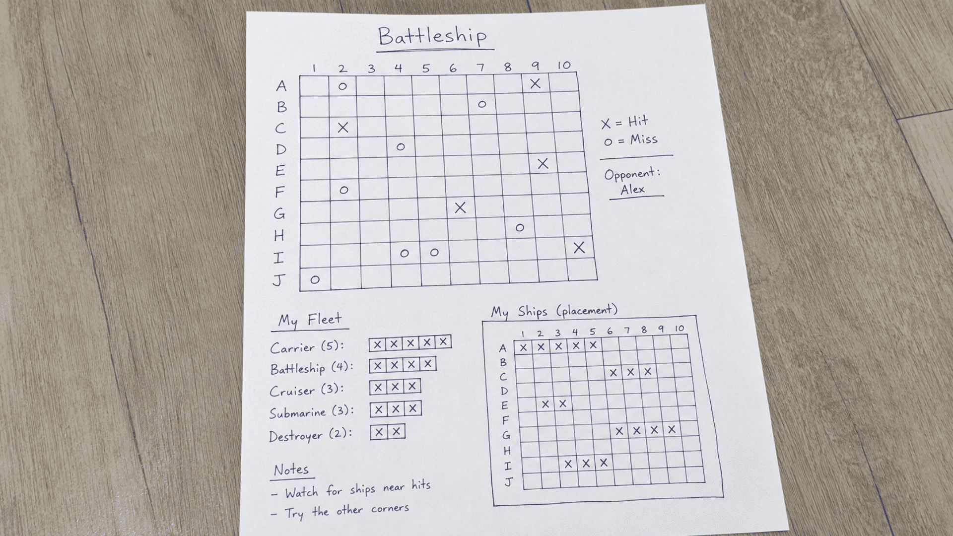 image of pen and paper game paper battleship setup on white paper handwritten rules and boxes to play battleship game