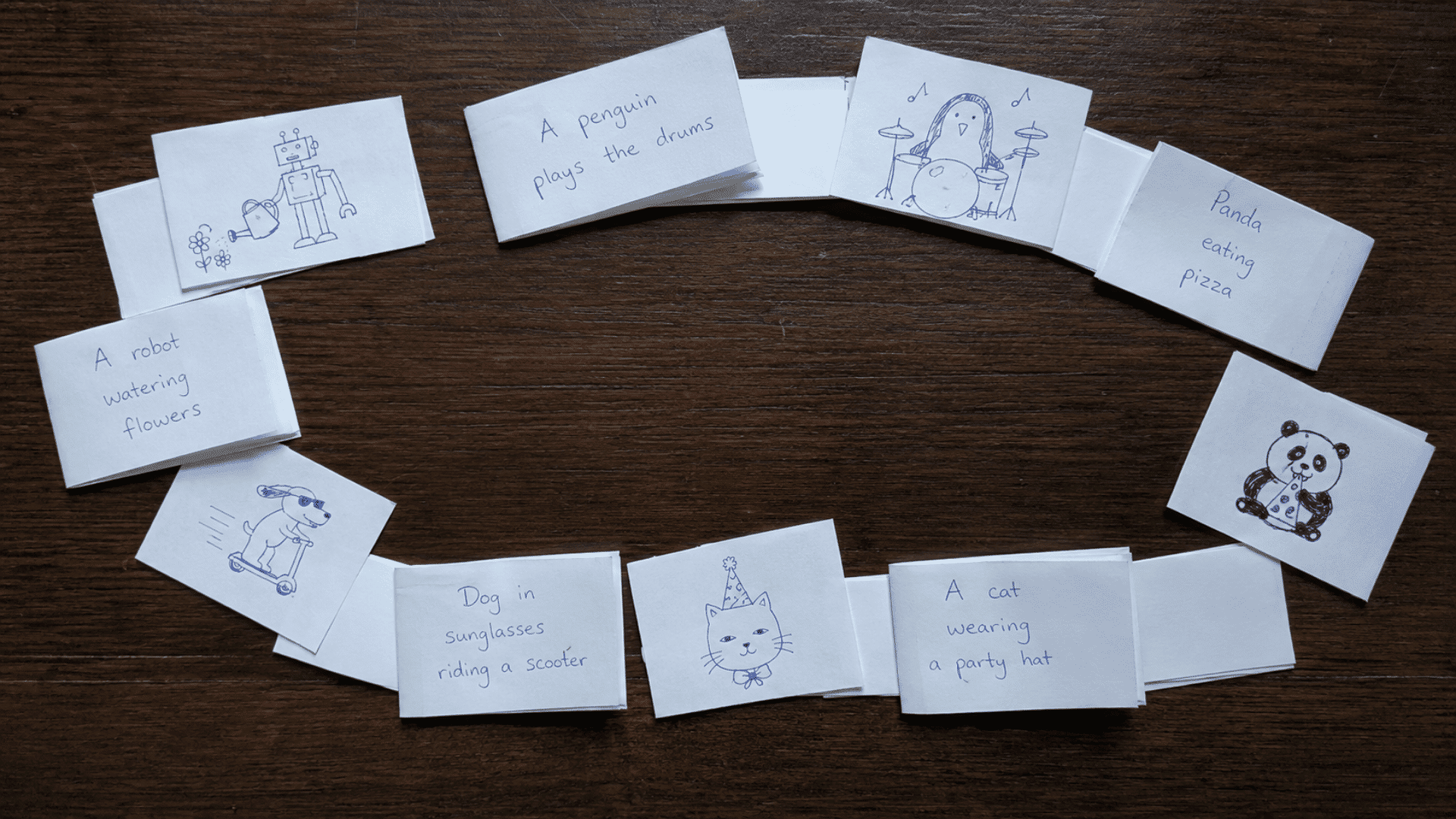 pen and paper game with setup for paper telephone game showing whimsical doodles on wooden tabletop with texts and drawings