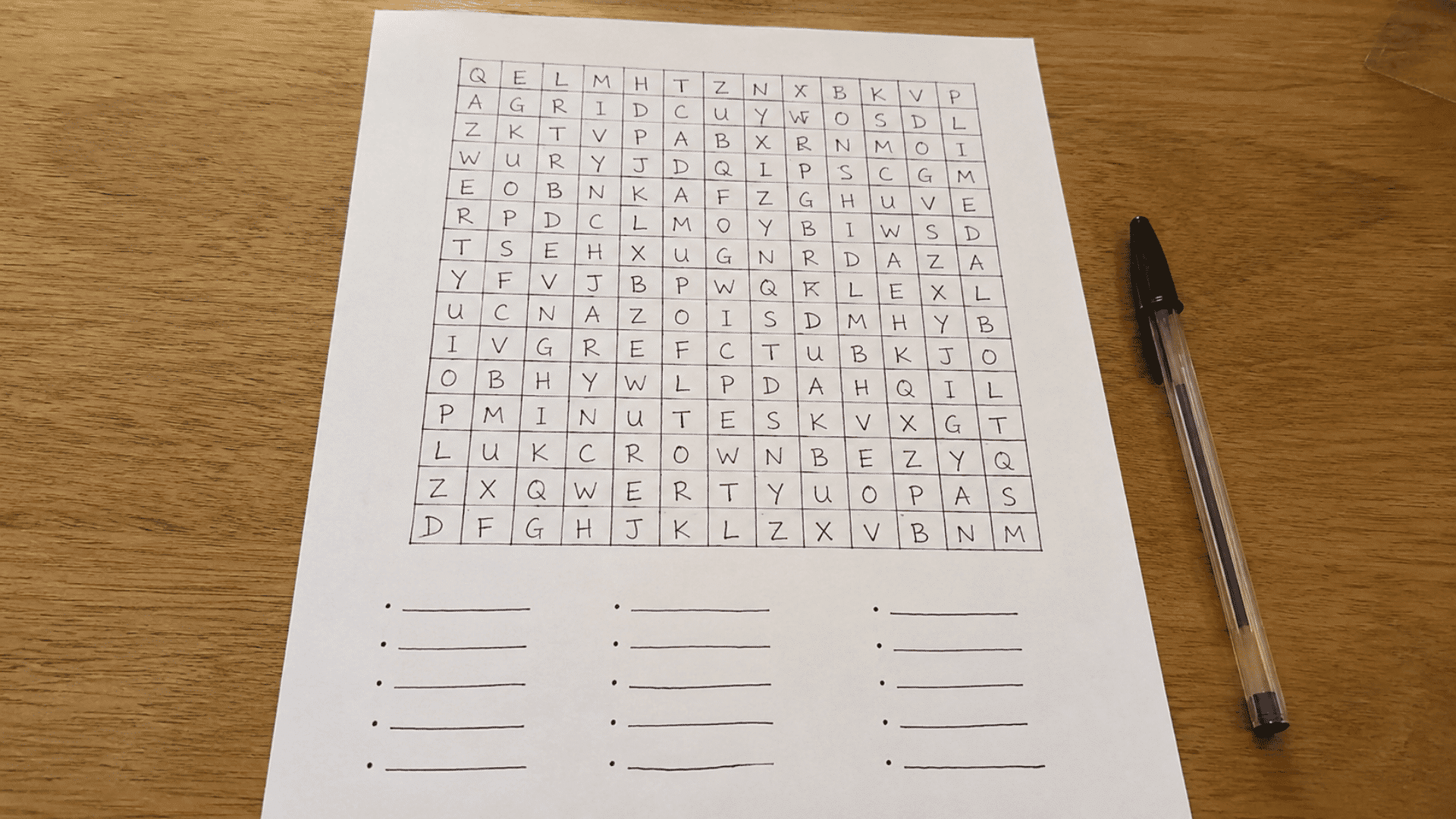 pen and paper games playing setup of hand drawn word search on wooden desk to play word search race