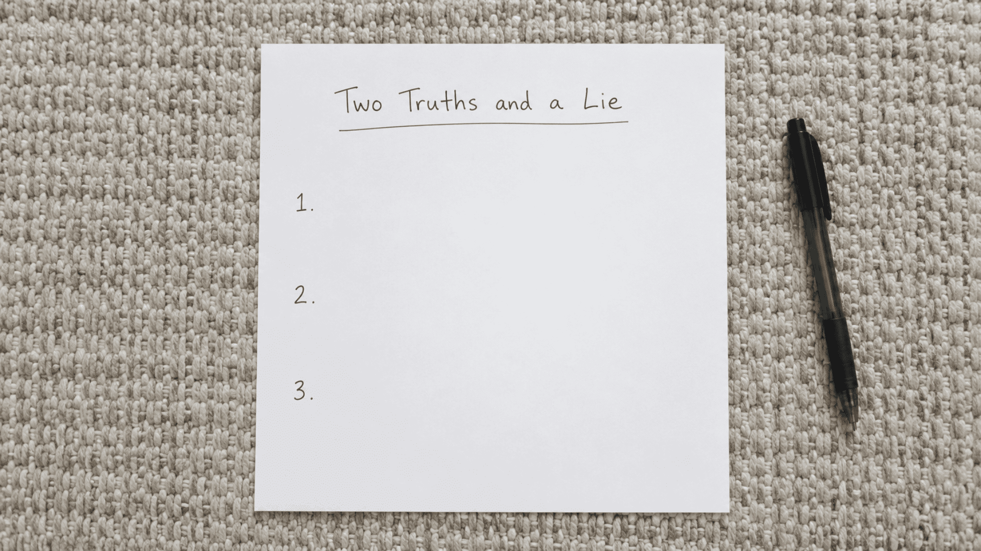 two truths and a lie pen and paper game setup on a woven jute floor white paper and black pen setup handwritten text