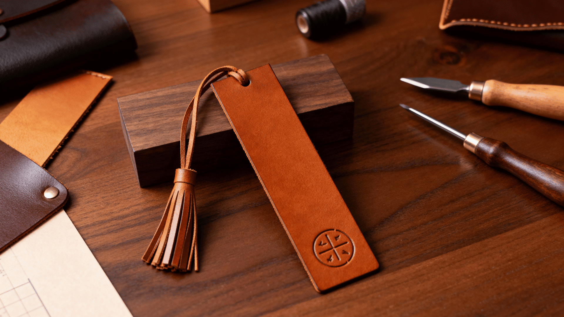 brown leather scrap bookmark with handmade details and cord tassel displayed on a rustic wooden craft surface (1)