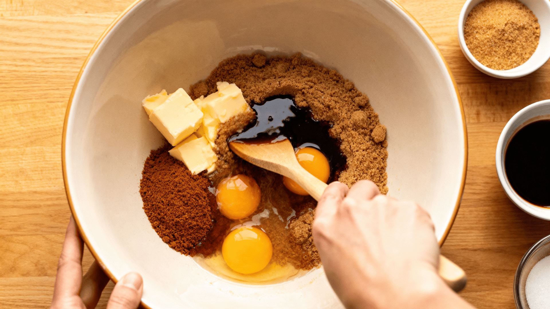butter, brown sugar, molasses and eggs blended in a bowl to create strong gingerbread house dough for baking