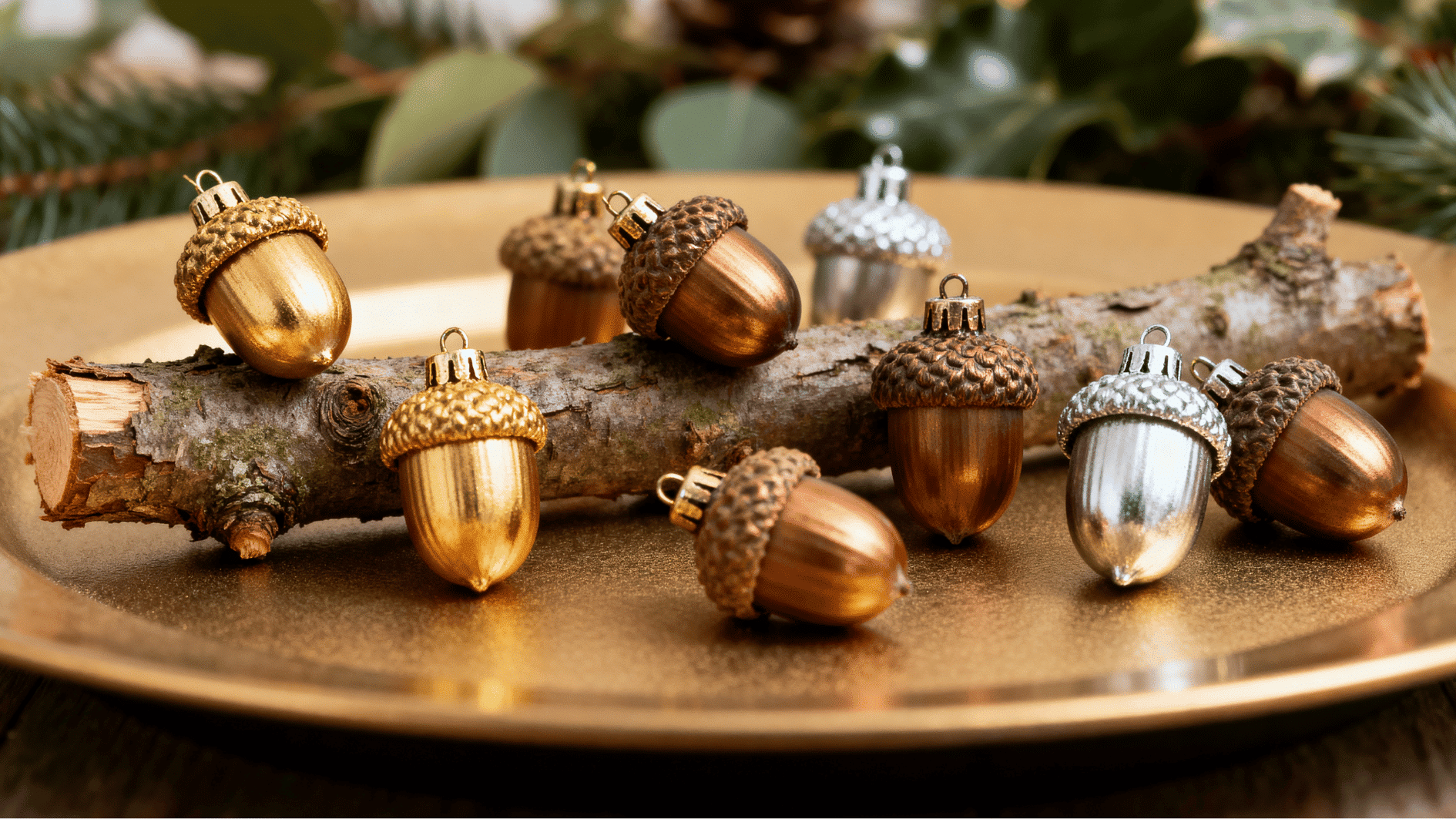 metallic acorn ornaments in gold copper and silver resting on branch with soft christmas bokeh lights cozy festive holiday decor