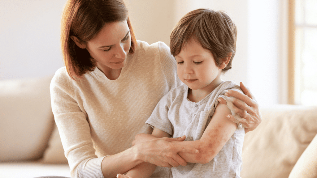 mother checking child arm rash while sitting together at home in soft natural light caregiving moment close up skin concern