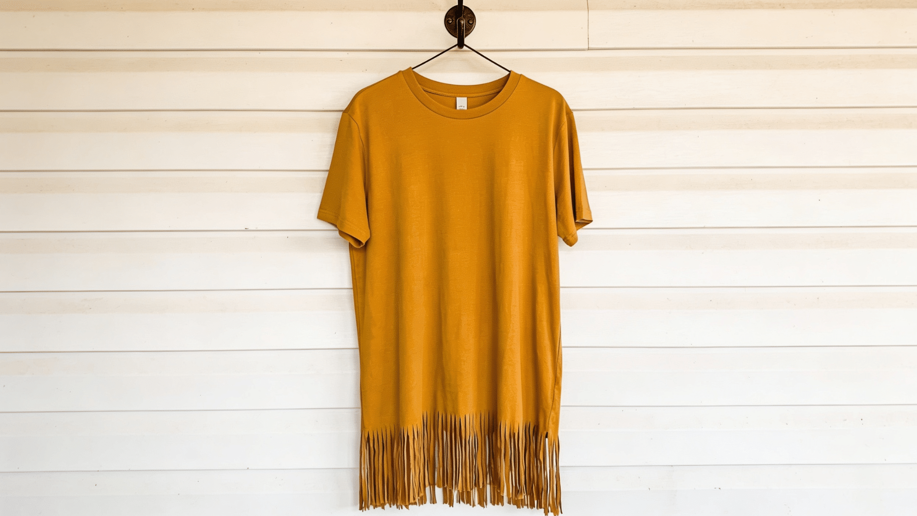 mustard yellow tshir, bottom portion cut in shagged lines to make design