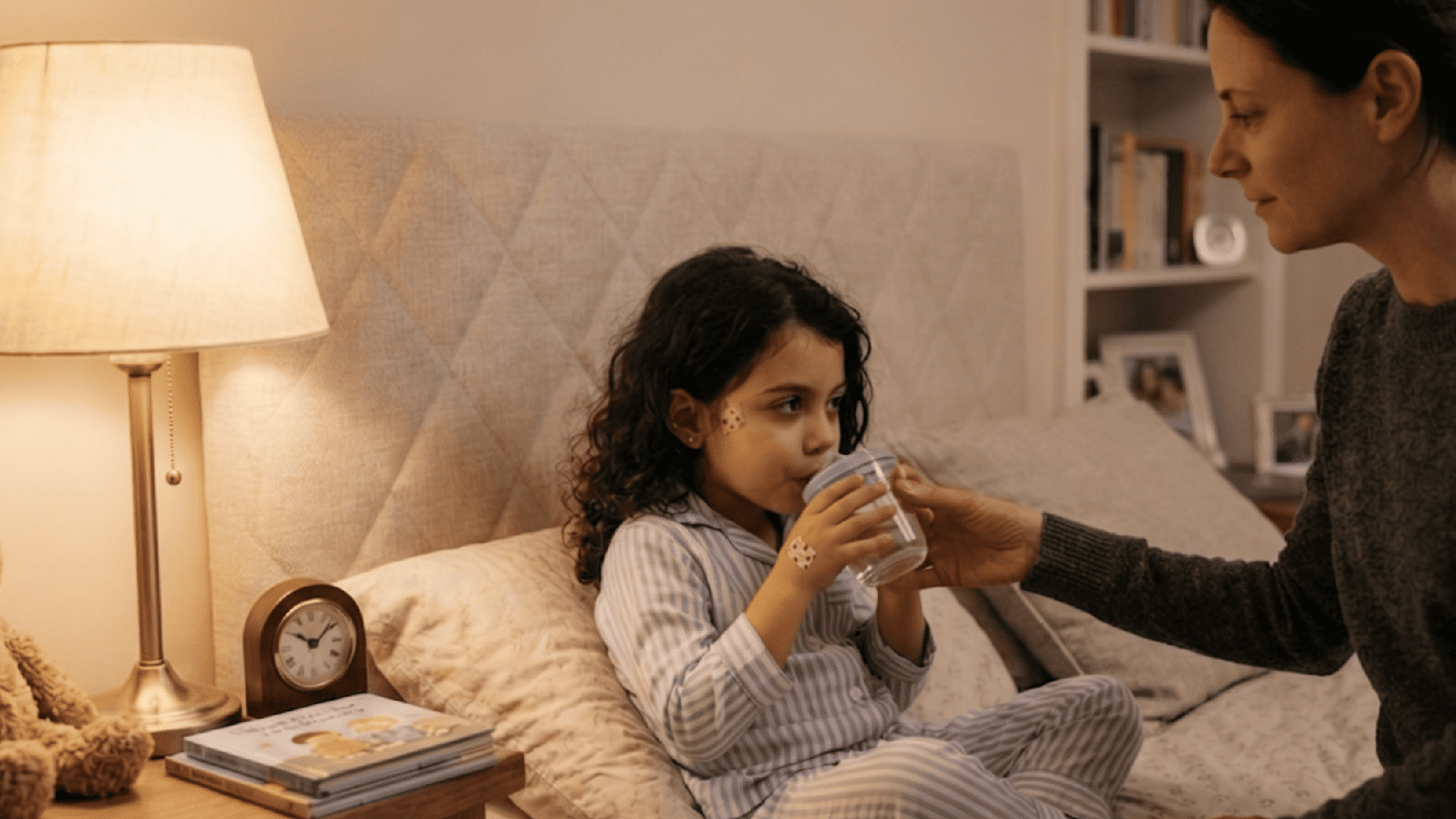 parent giving child water in bed to ease ear pain and support hydration at night