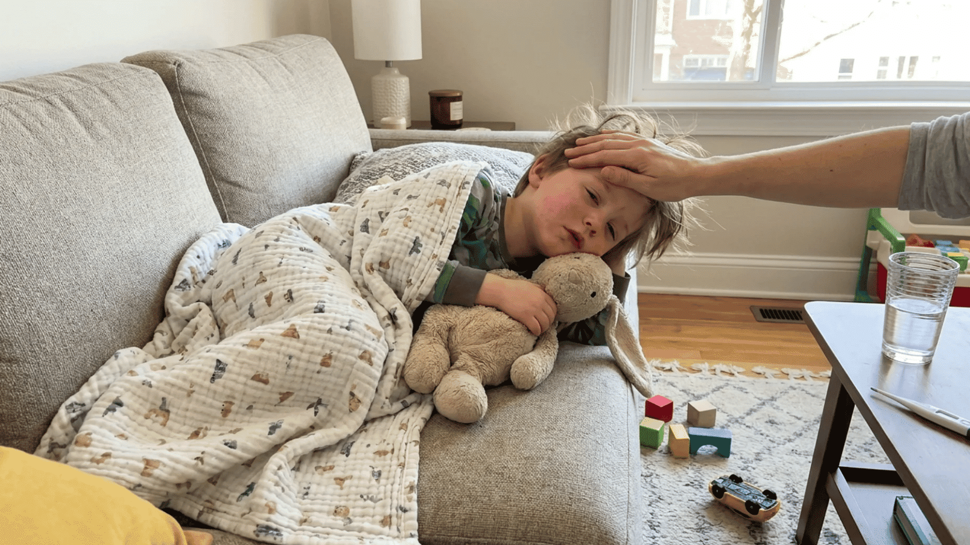 tired child resting on couch while recovering from fever