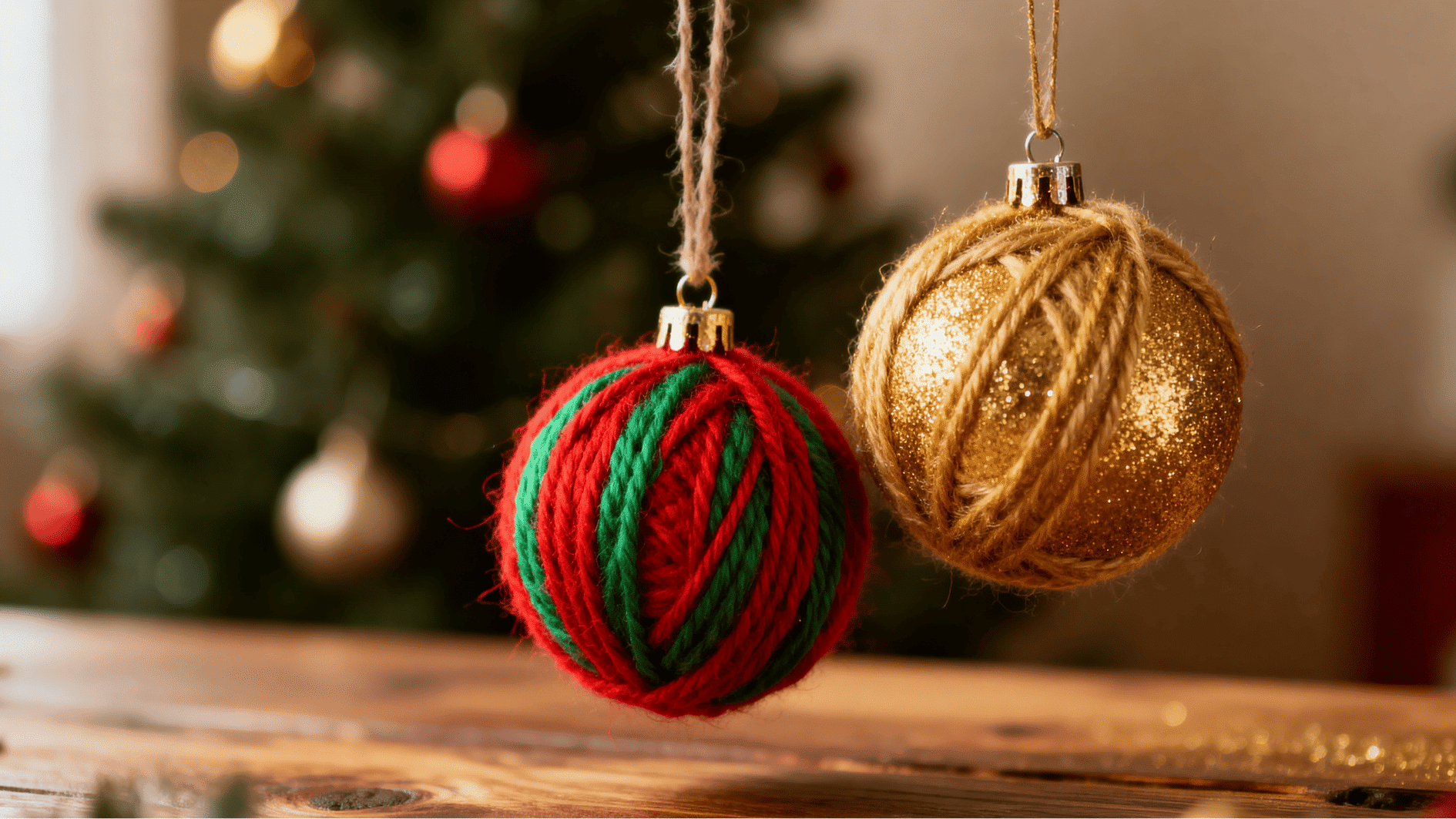 yarn wrapped christmas ornaments in red green and gold hanging on tree with warm fairy lights cozy festive holiday background