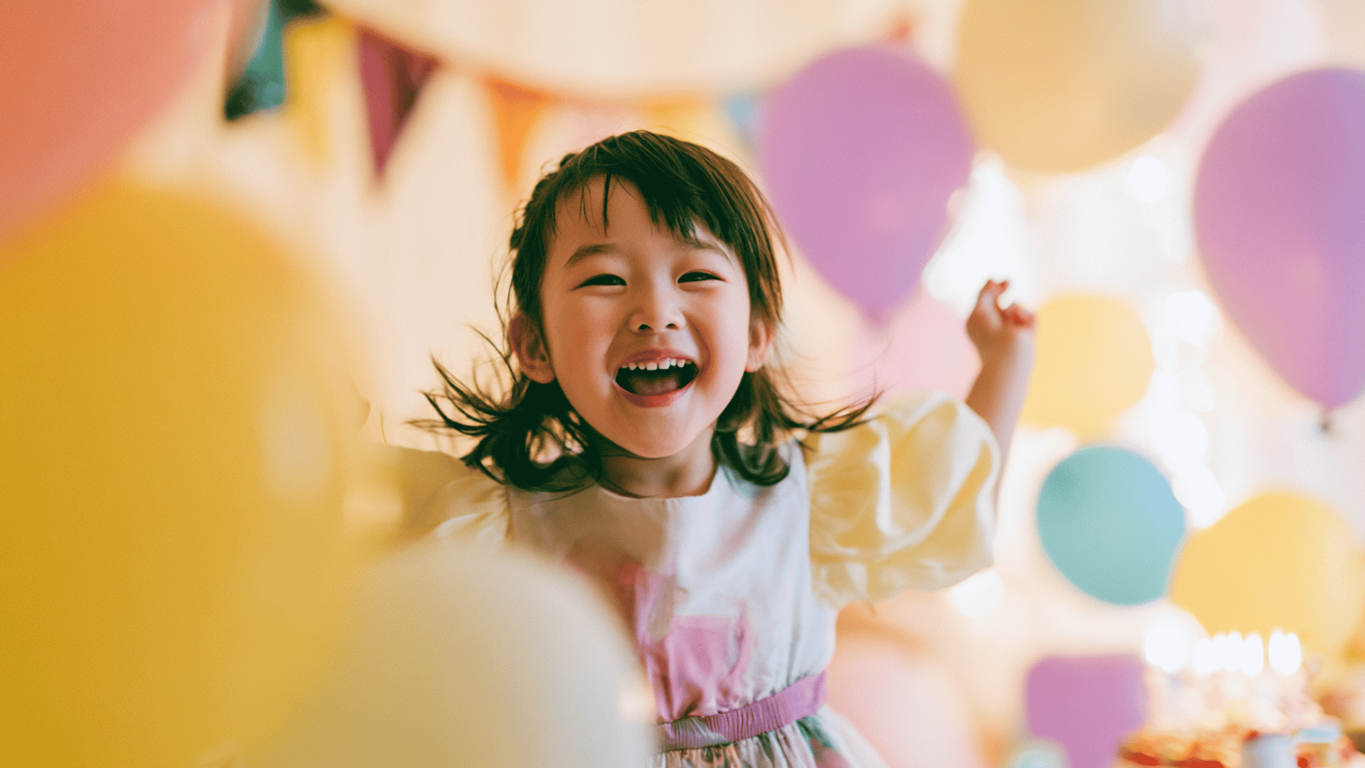 happy child smiling at a colorful birthday party with balloons and soft festive lights in the background
